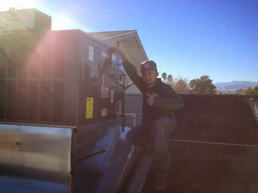 HVAC technician performing Boiler Repair on a rooftop unit in Boxborough